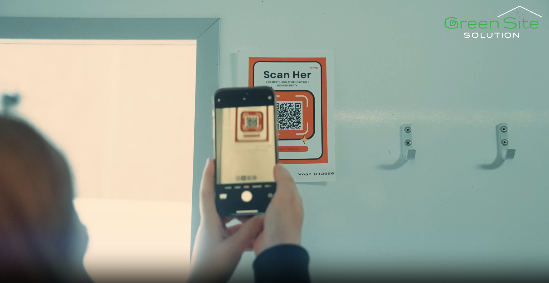 Medarbejder scanner QR-kode til bestilling af rengøring i skurvogn