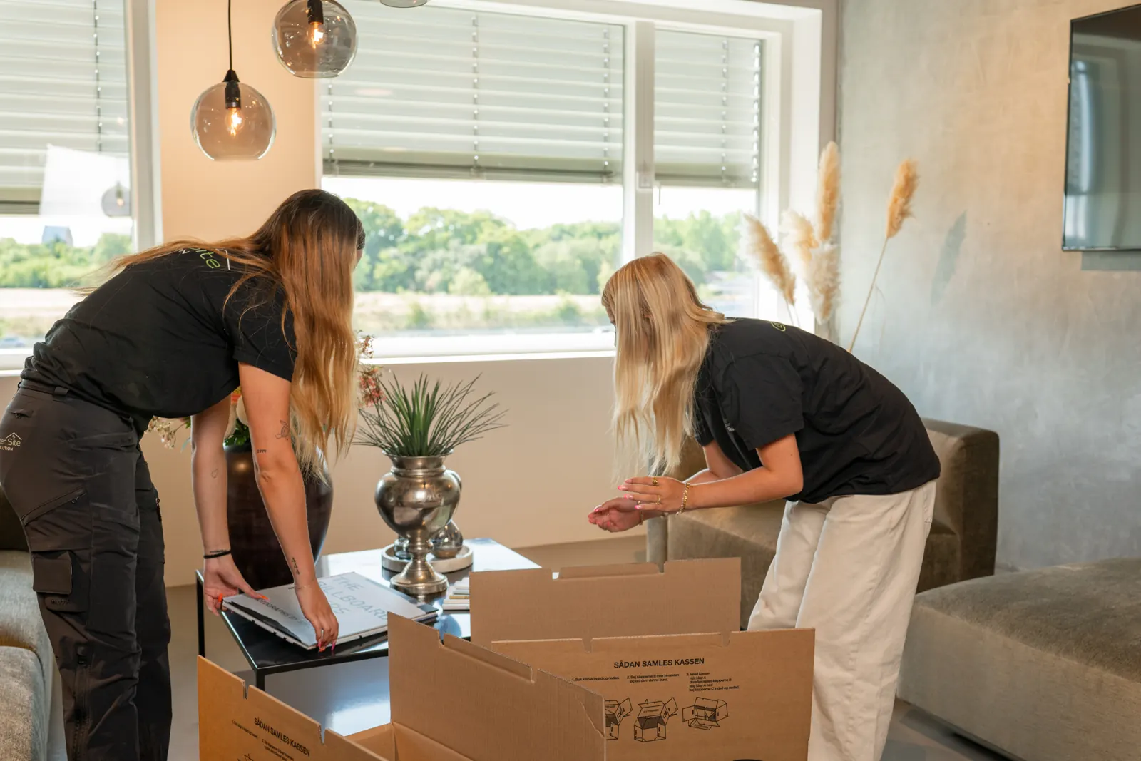 Medarbejdere pakker flyttekasser ned på kontoret fredag eftermiddag